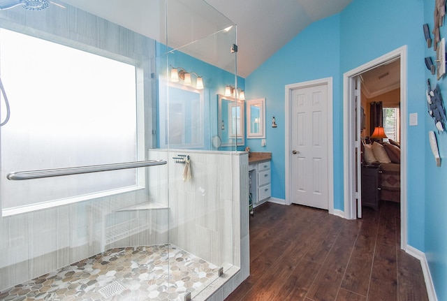 full bathroom with vaulted ceiling, tiled shower, wood finished floors, ensuite bathroom, and vanity