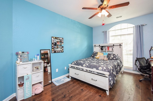 bedroom featuring wood finished floors, multiple windows, a ceiling fan, and baseboards