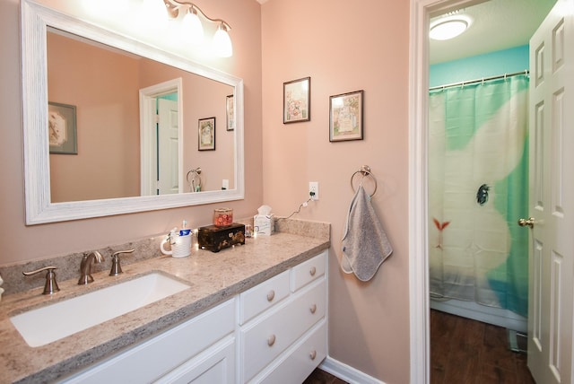 bathroom featuring vanity, wood finished floors, baseboards, and a shower with curtain