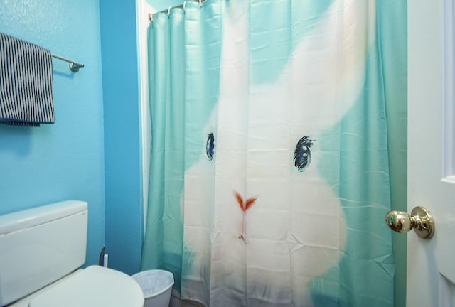 full bath with toilet and a shower with curtain