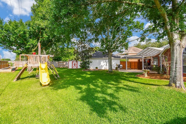 view of yard with a storage shed, a playground, and an outdoor structure