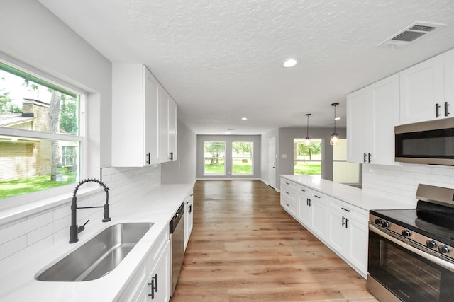 1914 Round Wind Trl, Crosby, TX 77532 - kitchen featuring stainless steel appliances, a sink, backsplash, recessed lighting, and light wood-style floors