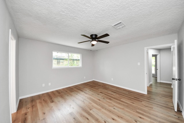 1914 Round Wind Trl, Crosby, TX 77532 - empty room featuring light wood-type flooring, ceiling fan, baseboards, and a textured ceiling