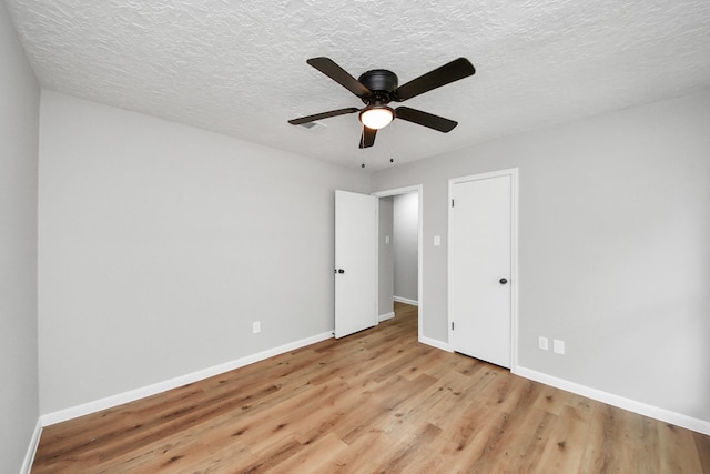 1914 Round Wind Trl, Crosby, TX 77532 - unfurnished bedroom with light wood finished floors, baseboards, a textured ceiling, and a ceiling fan