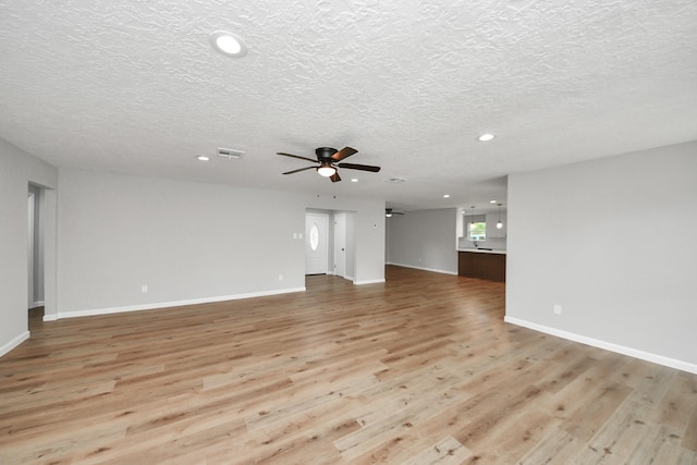 1914 Round Wind Trl, Crosby, TX 77532 - unfurnished living room with a ceiling fan, recessed lighting, light wood finished floors, a textured ceiling, and baseboards