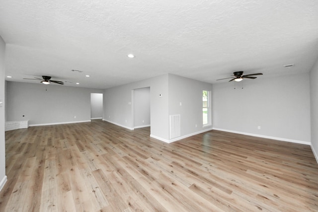 1914 Round Wind Trl, Crosby, TX 77532 - unfurnished living room with a ceiling fan, recessed lighting, light wood-style floors, baseboards, and a textured ceiling
