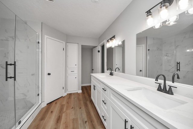 1914 Round Wind Trl, Crosby, TX 77532 - bathroom featuring a marble finish shower, wood finished floors, double vanity, and baseboards