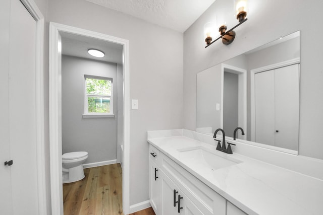 1914 Round Wind Trl, Crosby, TX 77532 - bathroom featuring wood finished floors, vanity, toilet, and baseboards