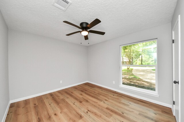 1914 Round Wind Trl, Crosby, TX 77532 - unfurnished room with light wood finished floors, baseboards, ceiling fan, and a textured ceiling