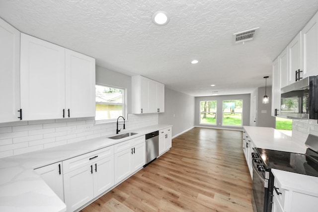 1914 Round Wind Trl, Crosby, TX 77532 - kitchen with appliances with stainless steel finishes, a sink, light wood-style floors, recessed lighting, and backsplash