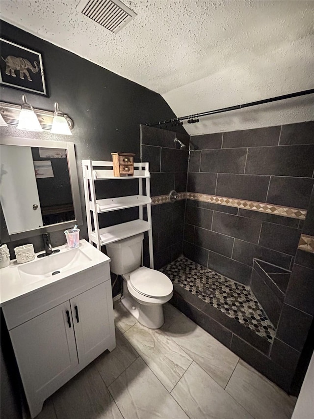 275 Georgia St, Houston, TX 77029 - full bathroom with tiled shower, toilet, a textured ceiling, vanity, and marble look tiles