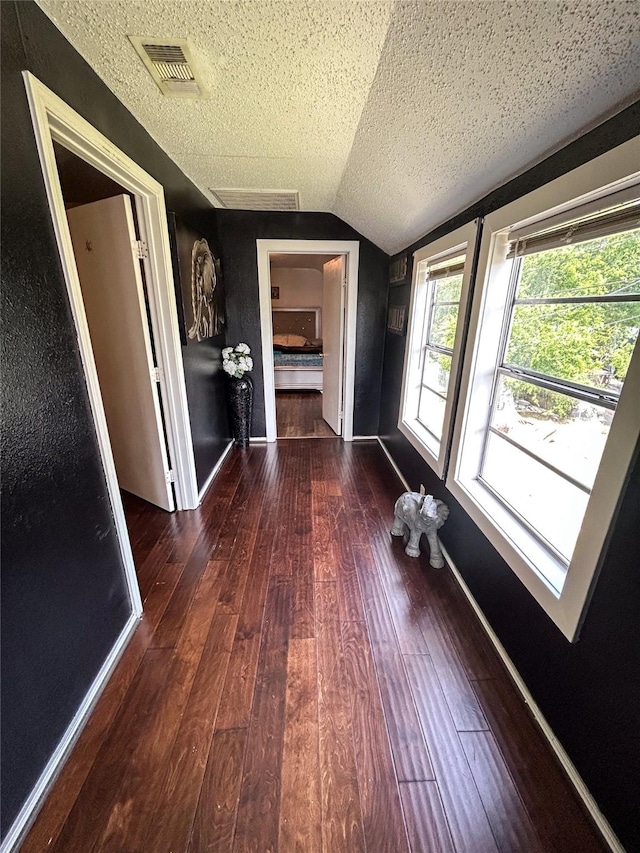 275 Georgia St, Houston, TX 77029 - corridor with vaulted ceiling, hardwood / wood-style flooring, a textured ceiling, and baseboards