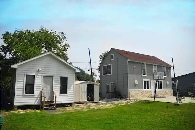 275 Georgia St, Houston, TX 77029 - back of house featuring entry steps, a shed, a lawn, an outbuilding, and a patio
