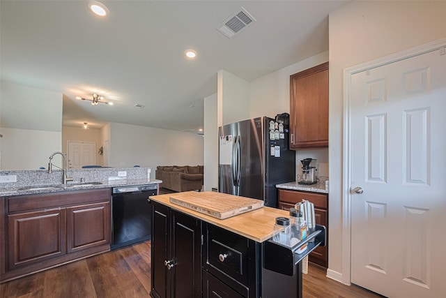 14502 Myrtle Hill Dr, Houston, TX 77069 - kitchen with black dishwasher, freestanding refrigerator, a sink, dark wood-style floors, and light stone counters