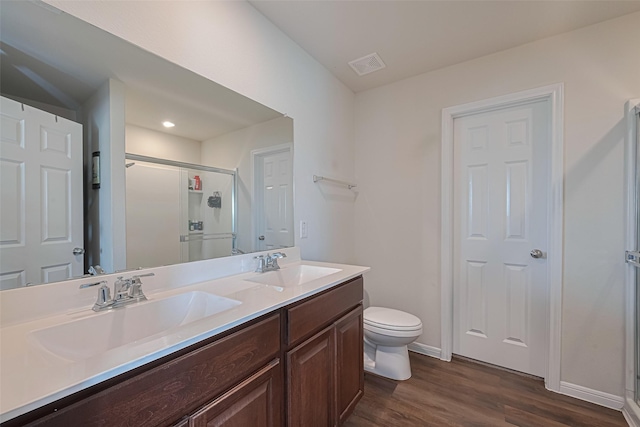 14502 Myrtle Hill Dr, Houston, TX 77069 - bathroom featuring a stall shower, wood finished floors, toilet, double vanity, and baseboards