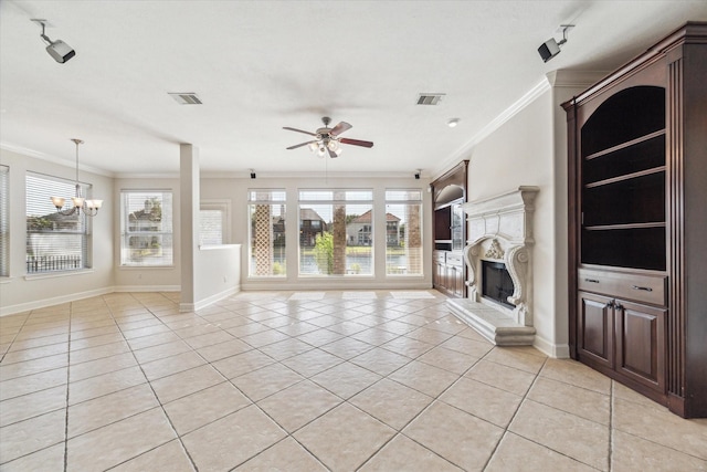 unfurnished living room featuring ornamental molding, light tile patterned floors, a ceiling fan, a fireplace, and a chandelier