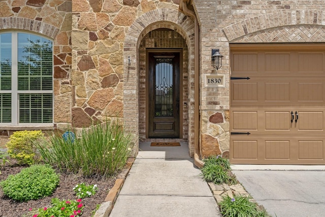 1830 Britton Key Ln, Spring, TX 77386 - doorway to property with stone siding, concrete driveway, a garage, and brick siding