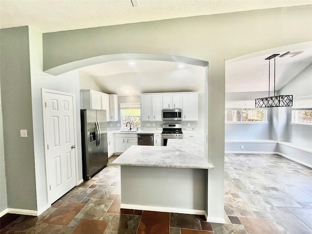 3209 Crimson Coast Dr, League City, TX 77573 - kitchen featuring appliances with stainless steel finishes, a sink, stone finish flooring, white cabinets, and plenty of natural light