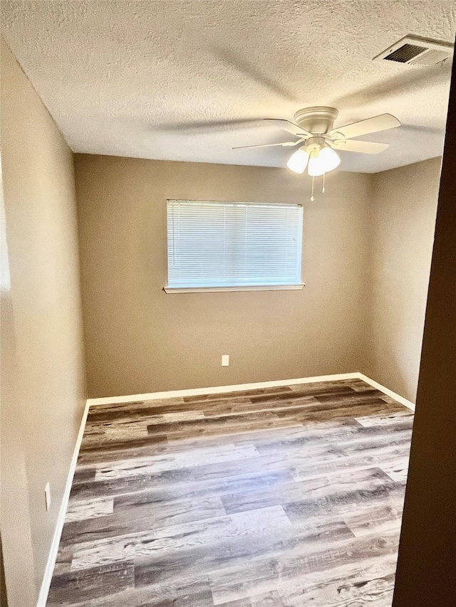 3209 Crimson Coast Dr, League City, TX 77573 - unfurnished room with a textured ceiling, baseboards, ceiling fan, and wood finished floors
