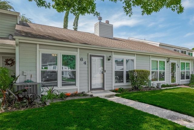 64 Hideaway Dr, Friendswood, TX 77546 - view of front of house featuring central AC unit, a front yard, and a chimney