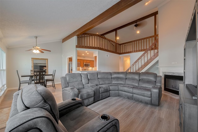 64 Hideaway Dr, Friendswood, TX 77546 - living area featuring a ceiling fan, light wood-style floors, crown molding, stairway, and a fireplace