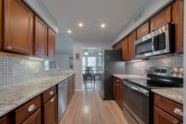 64 Hideaway Dr, Friendswood, TX 77546 - kitchen with appliances with stainless steel finishes, a sink, light wood finished floors, recessed lighting, and a ceiling fan