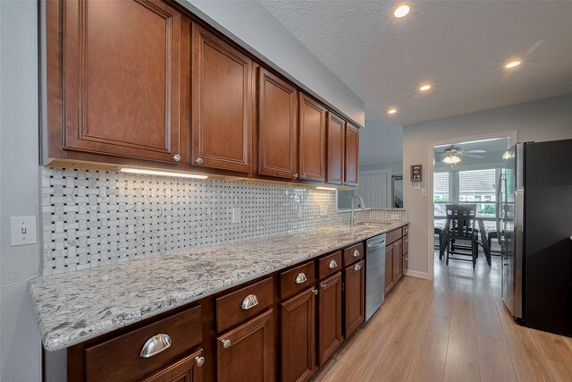 64 Hideaway Dr, Friendswood, TX 77546 - kitchen with appliances with stainless steel finishes, light wood finished floors, decorative backsplash, a sink, and recessed lighting
