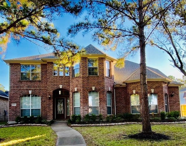 16535 Ruby Meadow Dr, Houston, TX 77095 - colonial-style house with brick siding, a front lawn, and roof with shingles