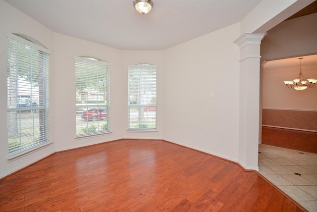 16535 Ruby Meadow Dr, Houston, TX 77095 - spare room featuring a chandelier, ornate columns, wood finished floors, and baseboards