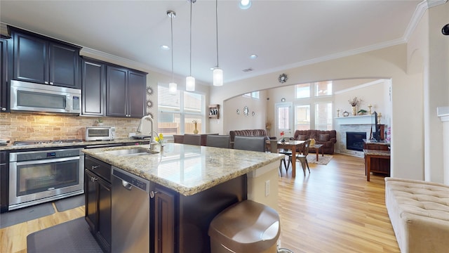 1911 Thunder Ridge Way, Houston, TX 77089 - kitchen with appliances with stainless steel finishes, a sink, crown molding, open floor plan, and plenty of natural light