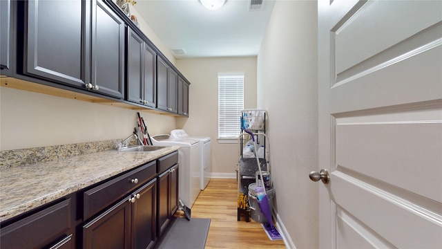1911 Thunder Ridge Way, Houston, TX 77089 - laundry area with cabinet space, independent washer and dryer, light wood finished floors, and baseboards