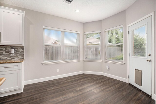 2385 Golden Shores Ln, League City, TX 77573 - unfurnished dining area featuring plenty of natural light, dark wood-style flooring, baseboards, recessed lighting, and a textured ceiling
