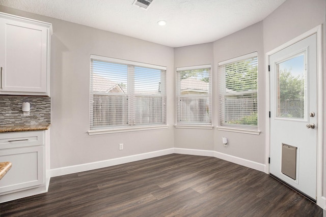 2385 Golden Shores Ln, League City, TX 77573 - unfurnished dining area featuring plenty of natural light, dark wood-style flooring, baseboards, recessed lighting, and a textured ceiling