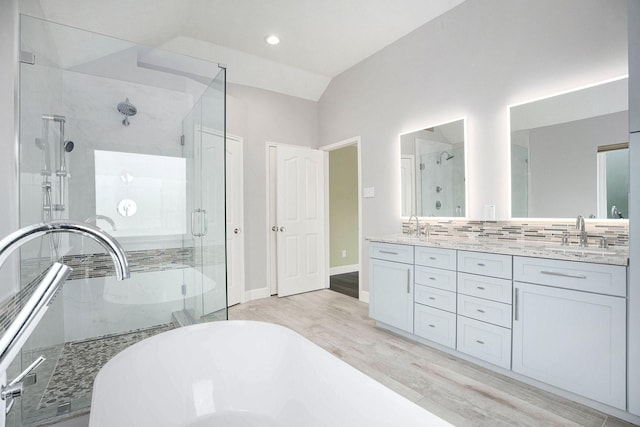 2385 Golden Shores Ln, League City, TX 77573 - bathroom featuring a soaking tub, wood finished floors, a stall shower, double vanity, and vaulted ceiling