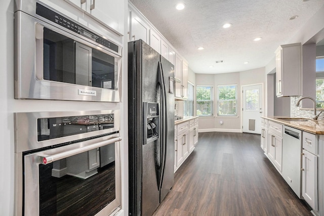 2385 Golden Shores Ln, League City, TX 77573 - kitchen featuring a sink, dishwasher, black refrigerator with ice dispenser, dark wood-type flooring, and a textured ceiling