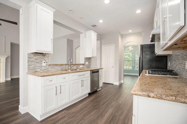 2385 Golden Shores Ln, League City, TX 77573 - kitchen featuring stainless steel appliances, a sink, arched walkways, baseboards, and dark wood-style flooring
