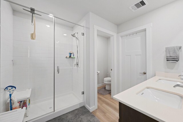 1242 Amistad Loop, College Station, TX 77845 - full bathroom featuring a stall shower, toilet, wood finished floors, and double vanity