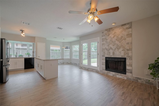 8547 Sparkling Springs Dr, Houston, TX 77095 - unfurnished living room featuring a fireplace, light wood-style floors, ceiling fan, and a sink