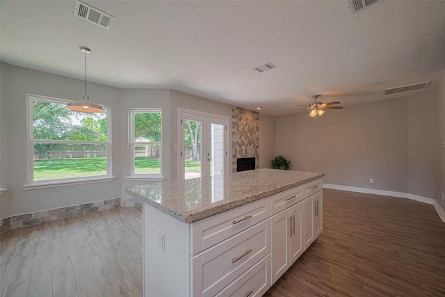 8547 Sparkling Springs Dr, Houston, TX 77095 - kitchen with baseboards, white cabinetry, wood finished floors, and a center island
