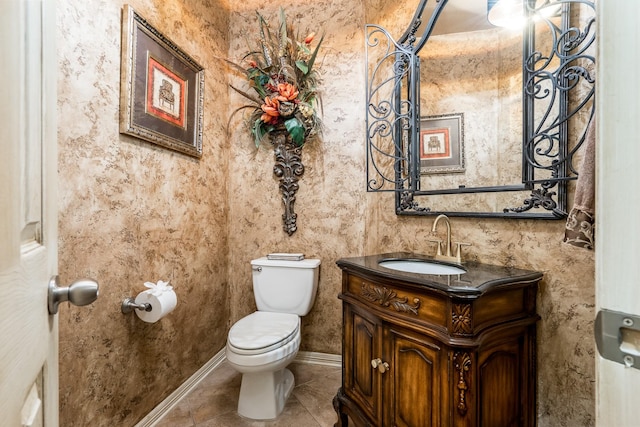 bathroom with toilet, tile patterned floors, vanity, and baseboards