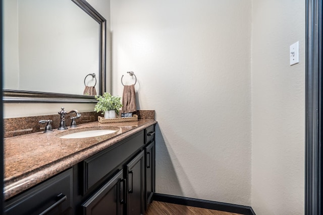 bathroom with vanity, baseboards, and wood finished floors