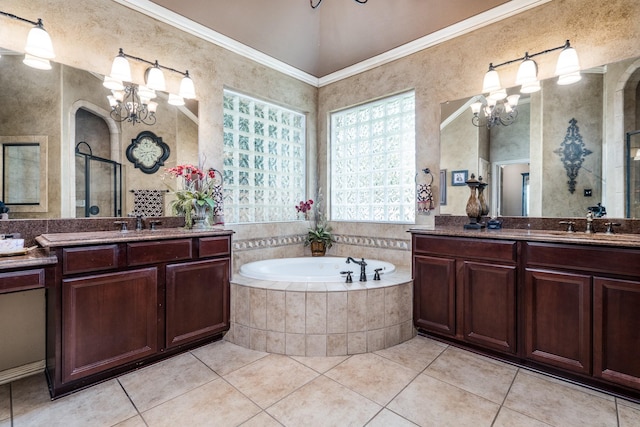 full bathroom featuring a chandelier, a shower stall, a garden tub, two vanities, and ornamental molding