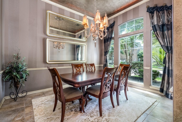 tiled dining space with a chandelier, ornamental molding, a textured wall, and baseboards
