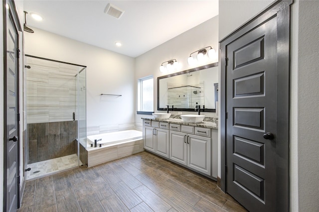 28723 Eden Creek Trl, Fulshear, TX 77441 - bathroom with a stall shower, a bath, double vanity, and wood finished floors