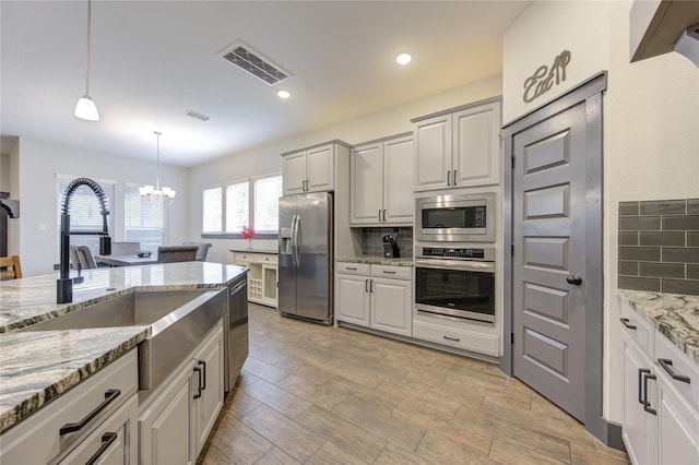 28723 Eden Creek Trl, Fulshear, TX 77441 - kitchen with appliances with stainless steel finishes, a sink, a chandelier, decorative backsplash, and recessed lighting