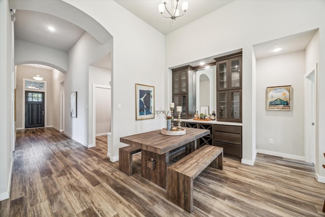 16707 Ramsay Cascades Dr, Humble, TX 77346 - hallway with arched walkways, baseboards, wood finished floors, a towering ceiling, and a chandelier