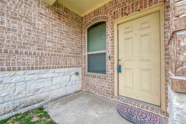 entrance to property featuring brick siding and a porch