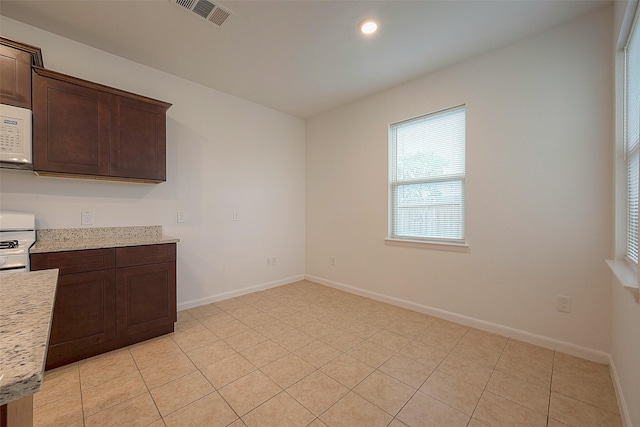 unfurnished dining area with baseboards, recessed lighting, and light tile patterned flooring