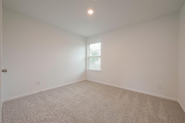 empty room featuring light colored carpet, baseboards, and recessed lighting