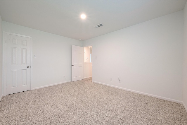 unfurnished room featuring light carpet and baseboards